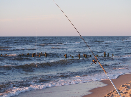 fishing-rod with spinning-wheel on sea backgroundの写真素材
