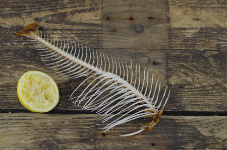 fish bone  and lemon on wooden backgroundの写真素材