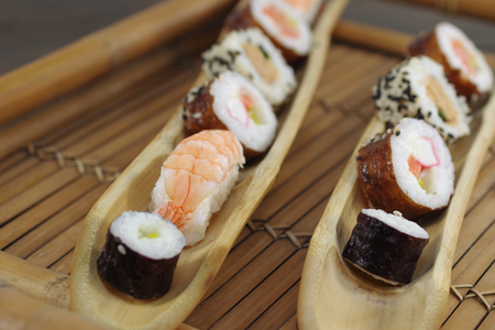  portion sushi and wooden hopsticks on plateの写真素材