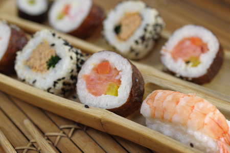  portion sushi and wooden hopsticks on plateの写真素材