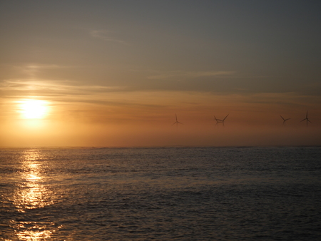 wind turbine at sea on sunset backgroundの写真素材