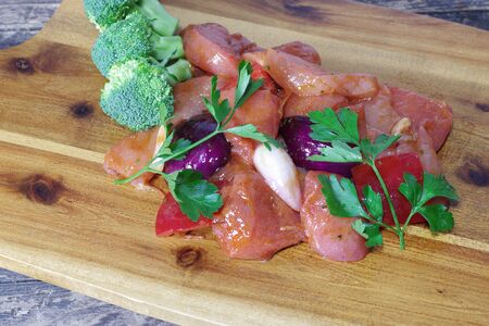 chicken meat with vegetables on wooden boardの写真素材