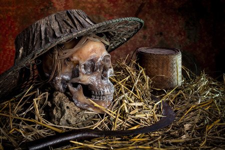 Still life with  skull cap machine weave on straw and sickle,rice kratibの写真素材