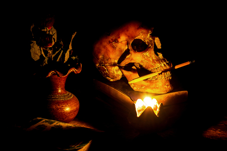 Skull and candle with candlestick on wooden background, still life conceptの写真素材