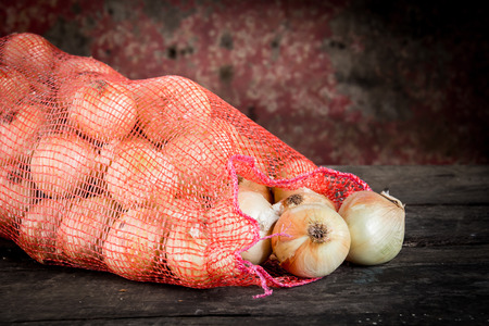 Pour the onion bag laid out on the old wooden floor , still lifeの写真素材