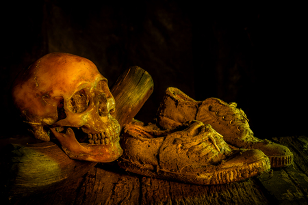 Still life with human skull and shoes on wooden backgroundの写真素材