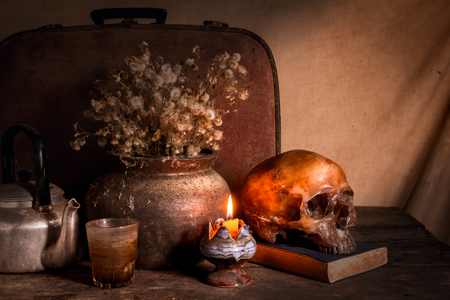 Human skull and flower vase old treasure on wooden table background, Still life conceptの写真素材