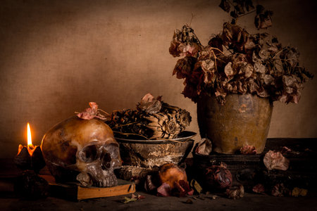 Human skull and candle with on wooden floor and old dirty wall background, and vase flower,and glass,and bottle of wine, still life conceptの写真素材