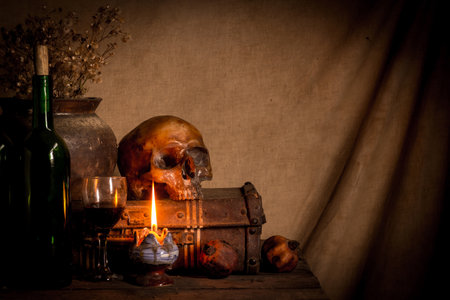 Still life with human skull, candle and chest on rustic backgroundの写真素材