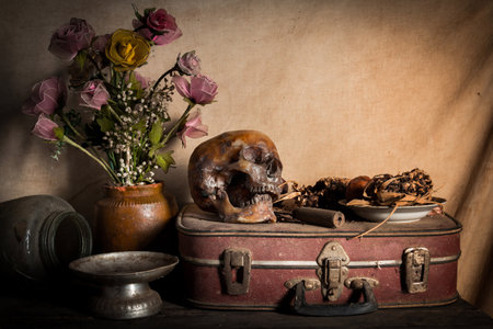 Human skull and flower vase old treasure on wooden table background, Still life conceptの写真素材