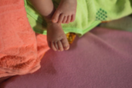 Blurred baby feet on the hands of the motherの写真素材