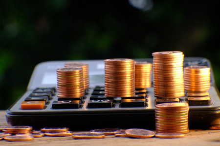 calculator and stack of coins on the table, business concept
