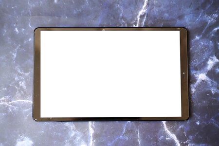 Tablet computer with blank screenle background. Top view.