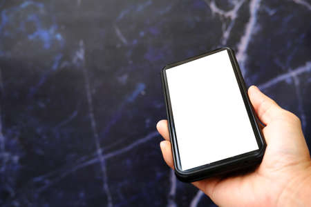male hand holds a smartphone with a white screen on a dark background
