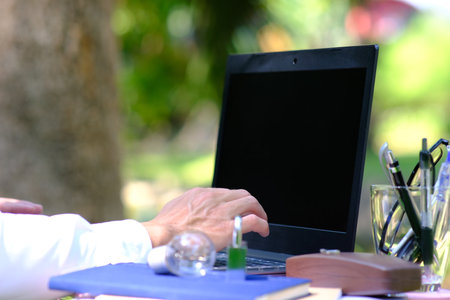 Close-up of a businessman working on a laptop in a park