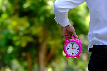 Businessman hand holding alarm clock and spaceの写真素材