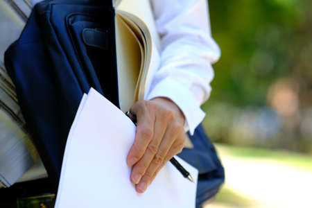 Close-up of a businesswoman holding documents in her hands.