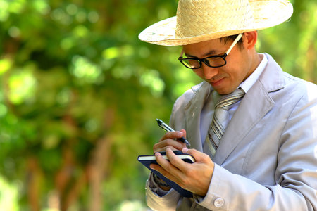Businessman using mobile phone in outdoor park. Business and technology concept.の写真素材