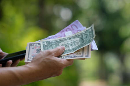 Man counting money in the park. Business and finance concept. Selective focus.の写真素材