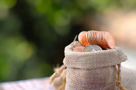 Coins in a sack on a blurred background. Saving money concept.の写真素材