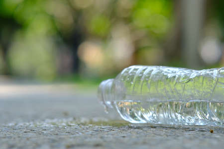 Plastic bottle of water on the floor in the park with blurred background.の写真素材