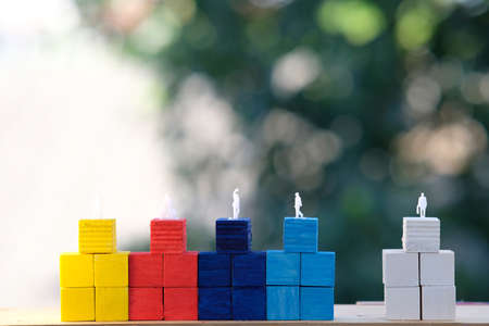 Wooden blocks with miniature people on top. Business development concept.の写真素材