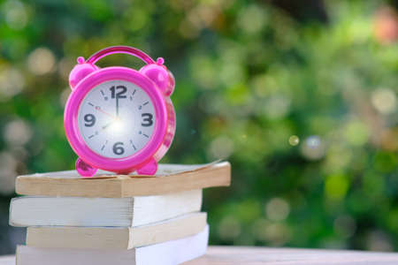 Alarm clock and book on table and space for textの写真素材
