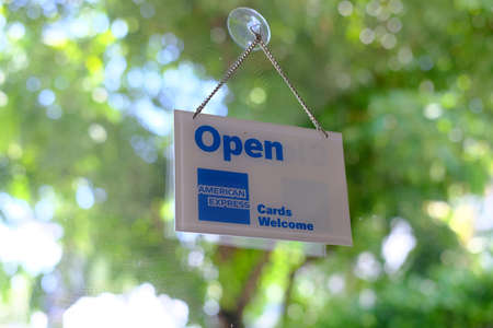 Open sign on the glass door in public park with bokeh backgroundの写真素材