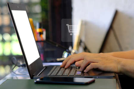 Online shopping concept. Close up of woman hand using laptop computer with blank screen.の写真素材