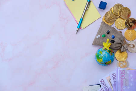 Money, globe, coins and notebook on pink background, space for textの写真素材