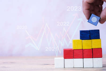 Business hand stack woods block step on table and Business growth up in year concept. business graph susessfulの写真素材