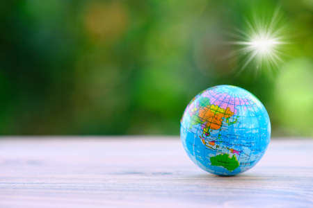 Globe on wooden table with green bokeh background. Earth day concept.の写真素材