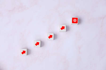 Business concept with red arrow on white wooden cubesle background.の写真素材