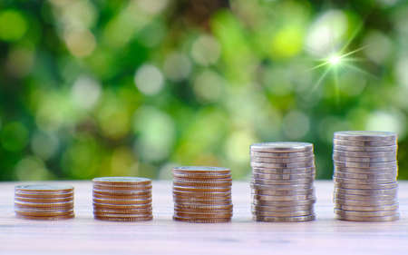 Stacking coins with green bokeh background ,Business Finance and Money concept, Advertising coins of finance and bankingの写真素材