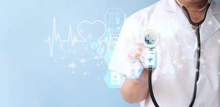 Health care and medical services concept. Doctor hand holding stethoscope and digital medical icons...