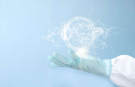 Hands in medical gloves touching hologram globe on light blue background, closeup. Space for textの写真素材