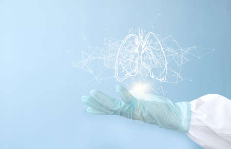 Doctor hand holding human lungs on light blue background, closeup. Space for textの写真素材