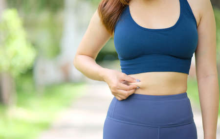Close-up of a woman in sportswear suffering from back painの写真素材