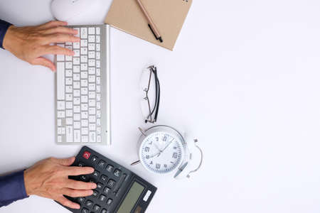 Top view of businessman working with calculator and keyboard on white desk.の写真素材