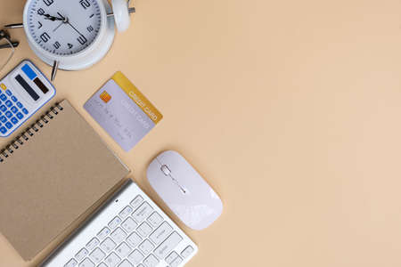 Flat lay composition with computer keyboard, mouse and credit card on beige background. Space for textの写真素材