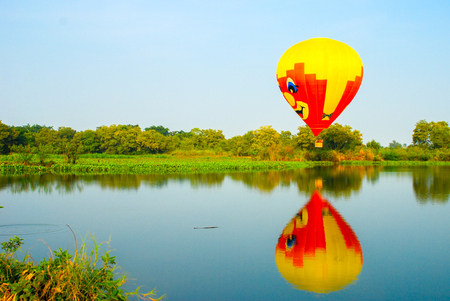 Balloons over the river . Composition of nature and blue sky background at Ayutthaya , thailand.の写真素材