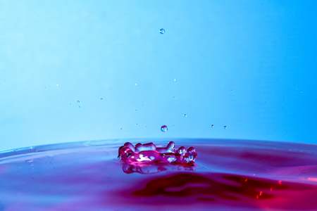 drop of water falling in blue water and blue background.の写真素材