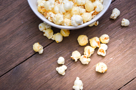 A bowl of popcorn on a wooden table.の写真素材