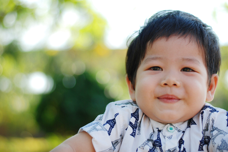 Portrait of a cute little Asia boy smiling . Portrait of young boy in nature,park or outdoorsの写真素材