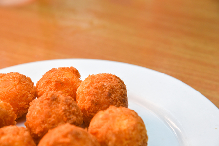 Cheese balls, Breaded mozzarella cheese balls with tomato in white dish on wood blackground.の写真素材