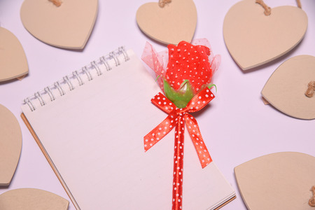 Red rose on  Blank notepad for copy space and Wooden hearts shape  on white blackground . Valentines Day background.  .  wedding dayの写真素材