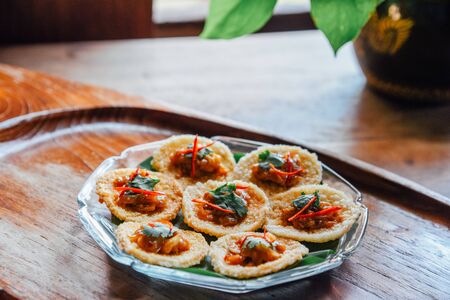 Crispy rice cake and pork and shrimp dipping in plate on wood table. thai foodの写真素材