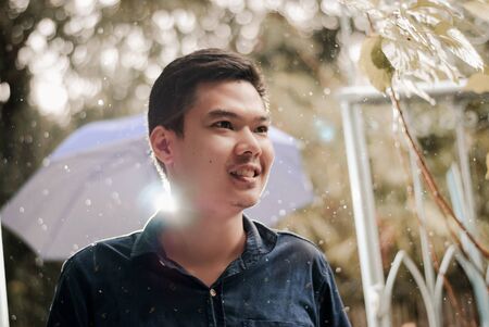 The rain falls, the drops fall on his face and the boy is happy with life and nature around, concept...