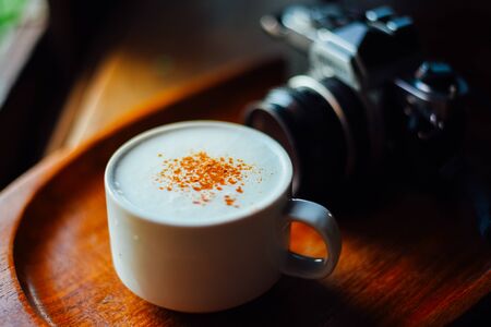 Hot cappuccino and Vintage camera on wood table ,  The drink menu . cafe image
