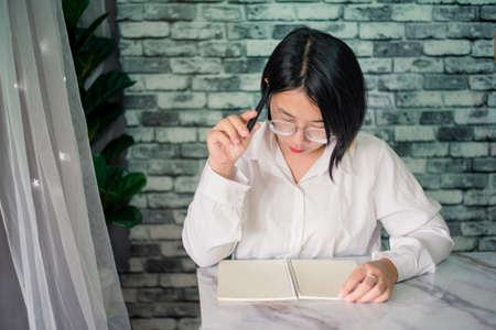 Portrait of young woman thinking while serious working  at home with laptop on desk